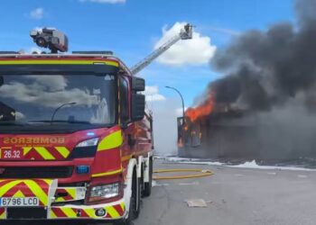 Doce dotaciones de bomberos controlan un incendio de cartón y papel en una nave industrial de Alcalá
