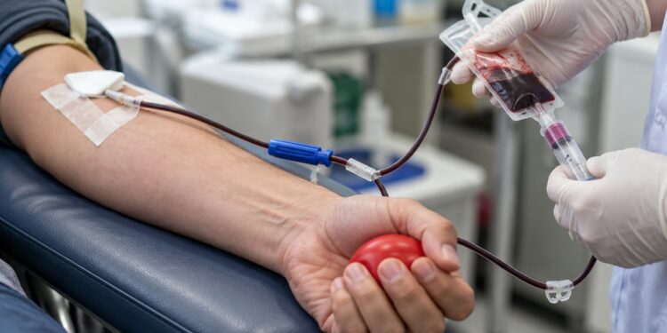 El Hospital Príncipe de Asturias recibe cerca de 170 donantes tras el accidente de Toledo y pide escalonar las donaciones 1 Primer plano de una donación de sangre con brazo del donante y personal sanitario sin rostros visibles